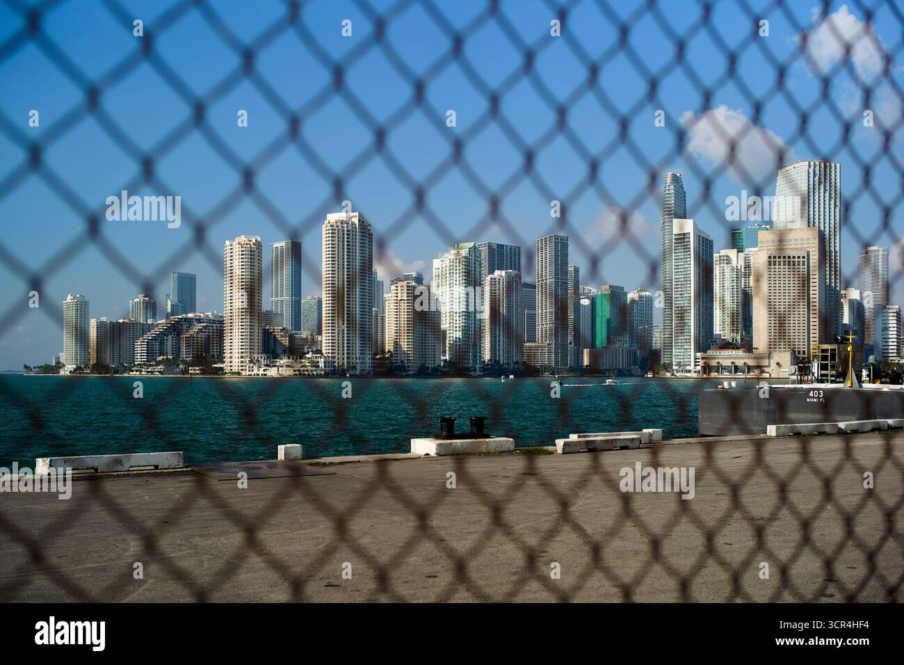 Die Skyline von Miami wird an einem sonnigen Tag durch einen Maschendrahtzaun betrachtet. Miami, Florida, USA Stockfoto