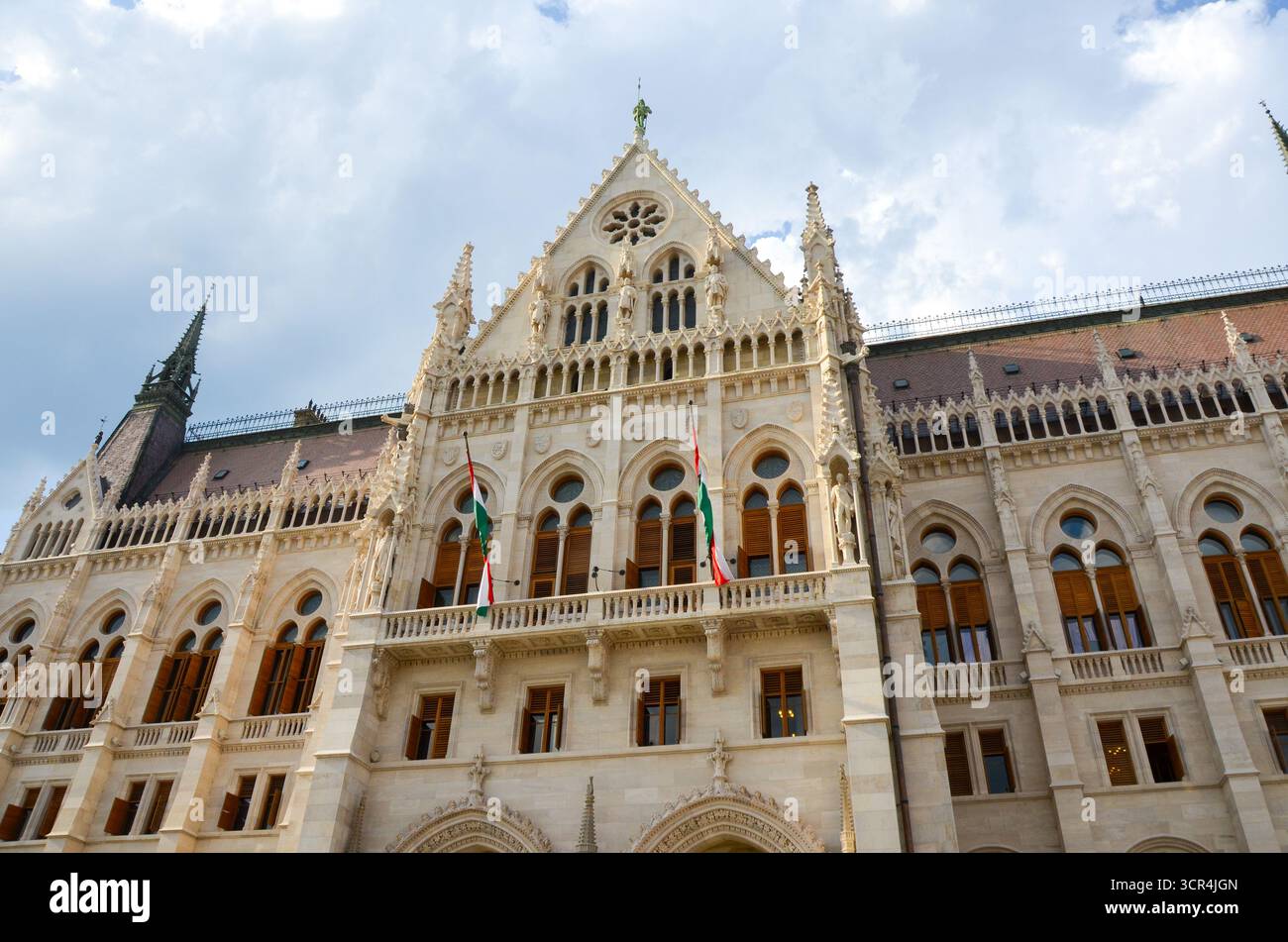 Architektonische Details der Fassade des ungarischen Parlamentsgebäudes mit ungarischen Fahnen auf dem Kossuth-Lajos-Platz in Budapest, Ungarn. Stockfoto