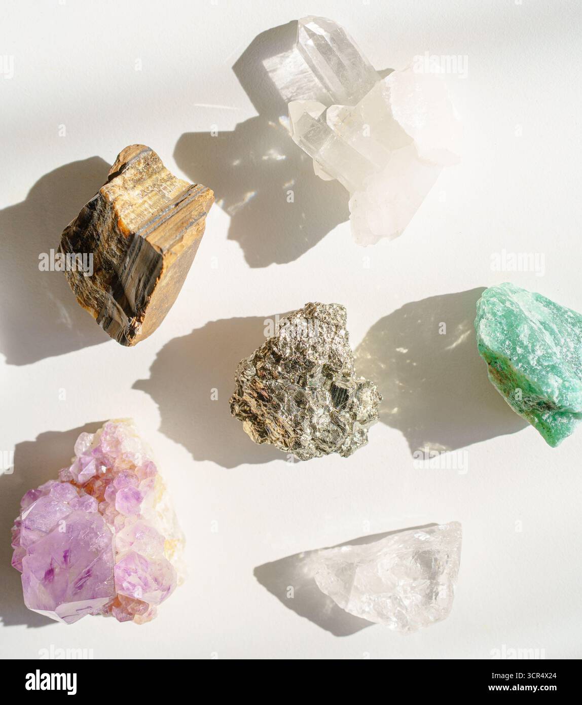 Bunte rohe Kristalle auf weißem Hintergrund Stockfoto