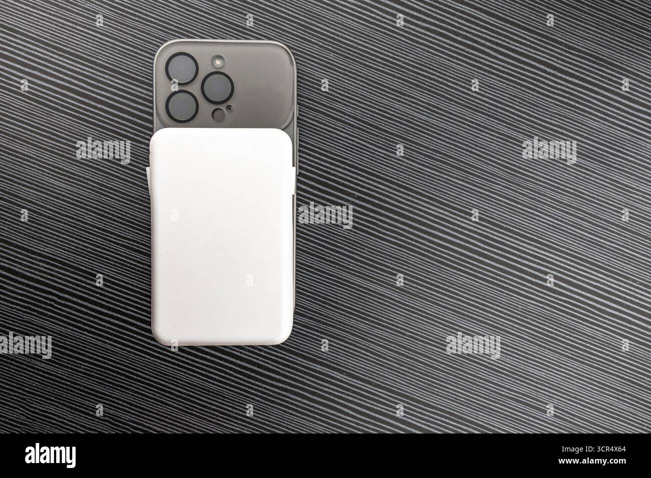 Ein zusätzlicher Akku zum Aufladen Ihres Telefons, magnetisch an der Hülle befestigt, eine zusätzliche Energiequelle für Ihr Mobiltelefon. Stockfoto