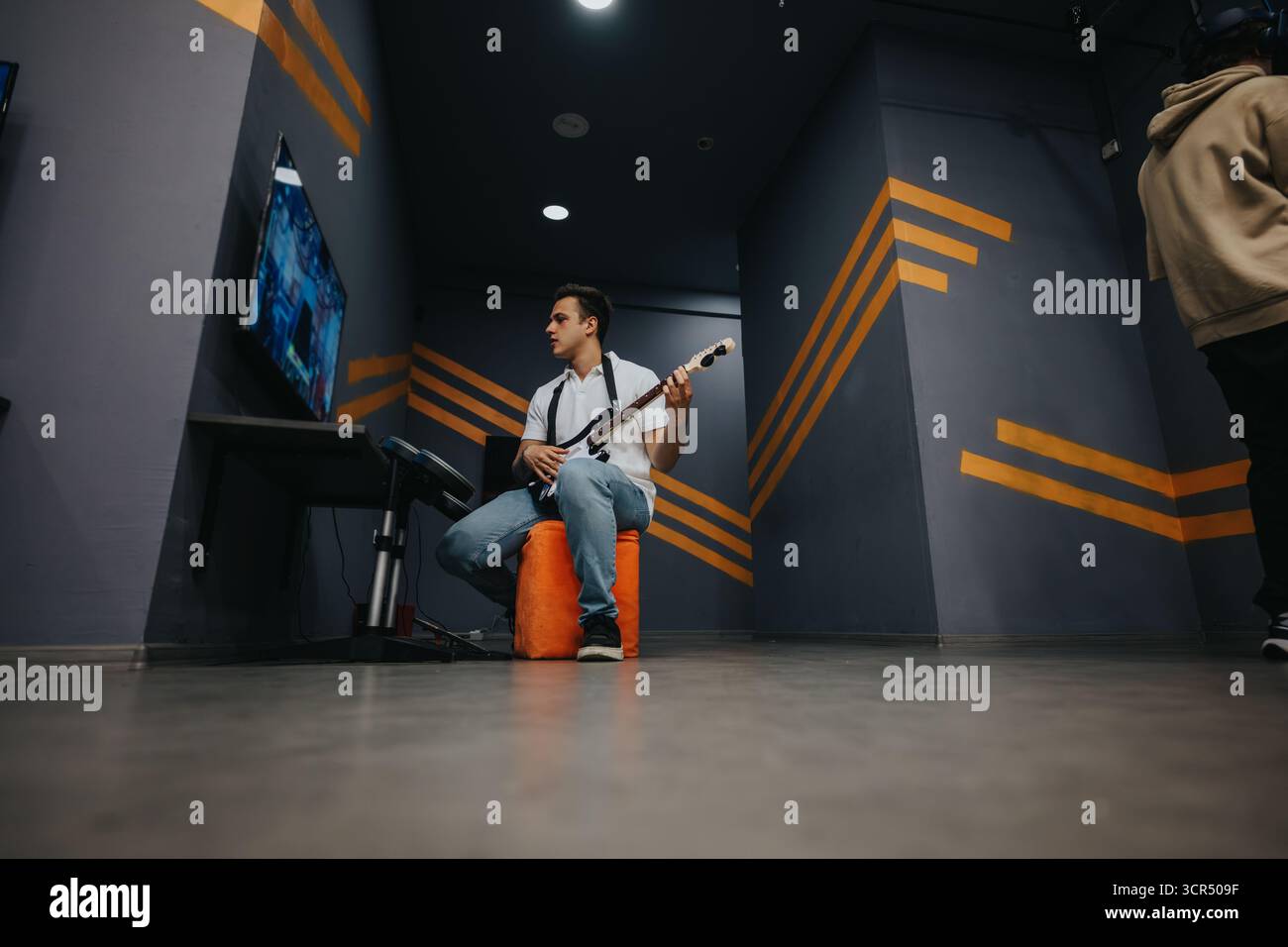 Junge Person, die ein Instrument in einem modernen Raum spielt Stockfoto