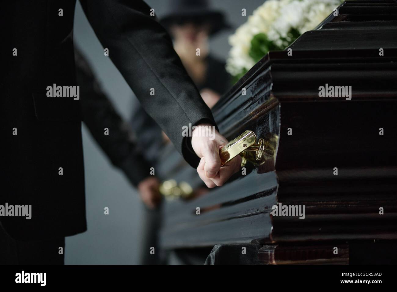 Mann schließt Sarg während der Trauerfeier in Traueratmosphäre Stockfoto