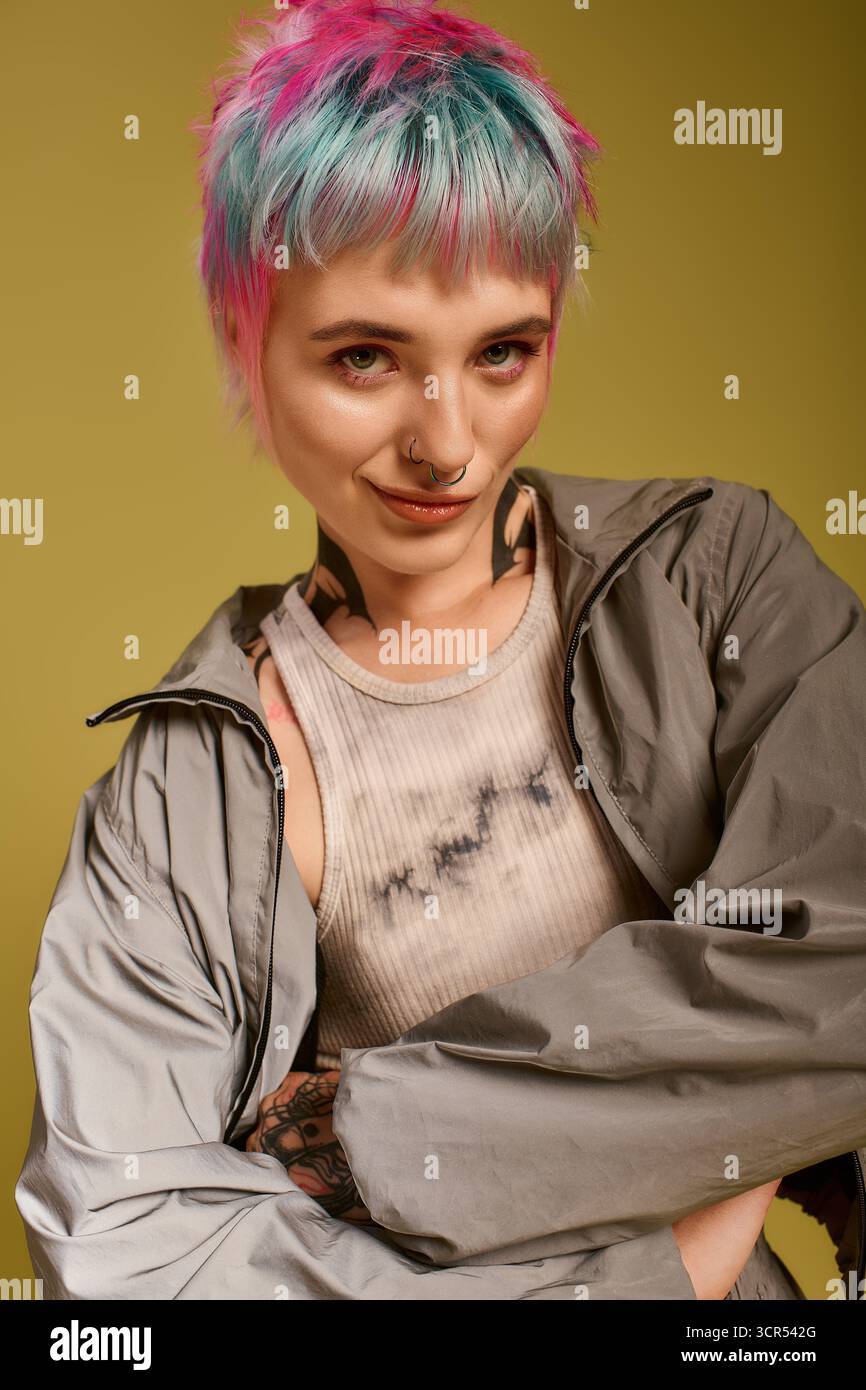 Eine junge Frau mit kurzen, bunten Haaren posiert selbstbewusst in einem Studio und drückt ihre Individualität aus. Stockfoto