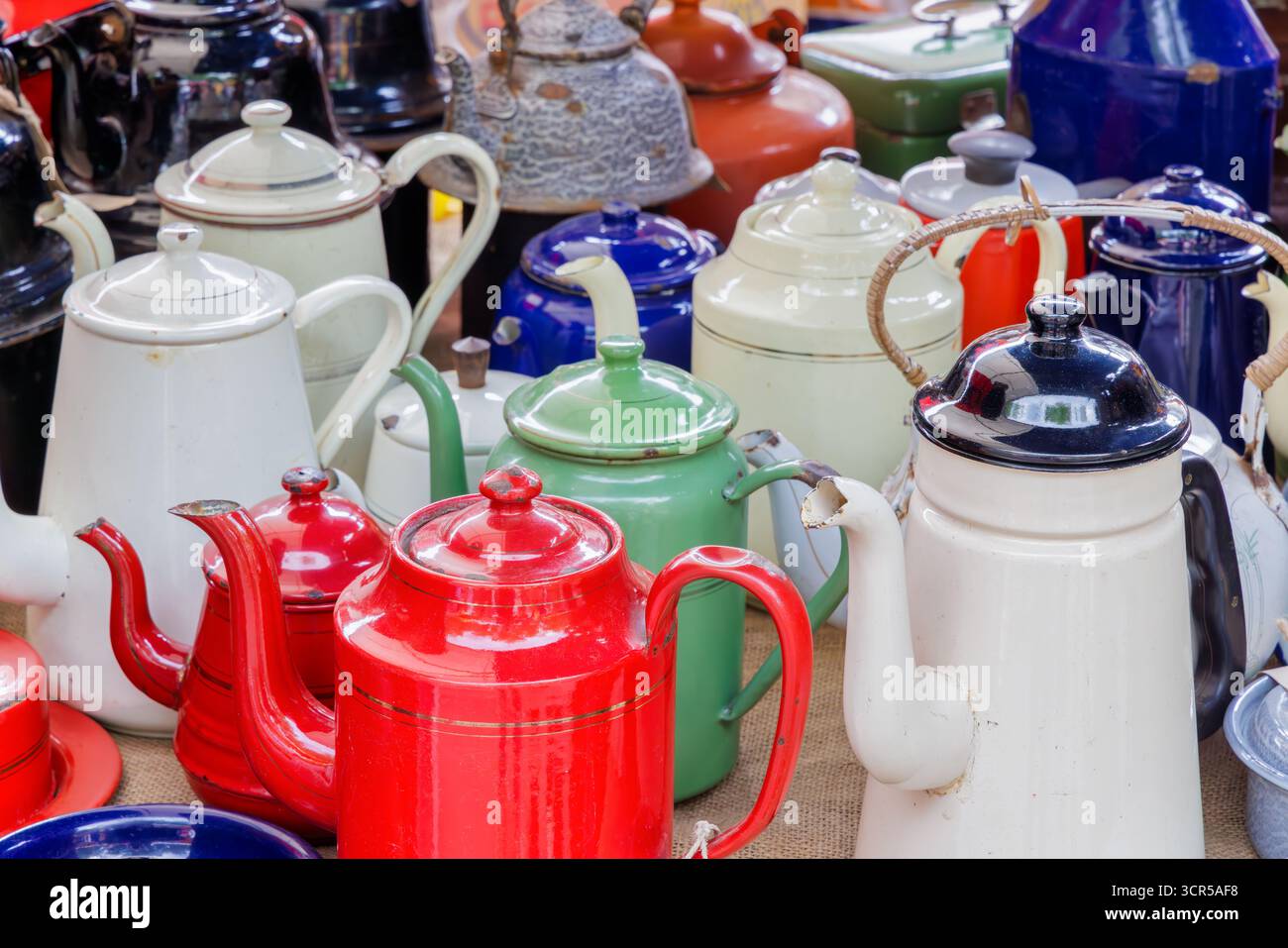 Vintage Emaille Teekessel in verschiedenen Farben auf einem Flohmarkt Stockfoto