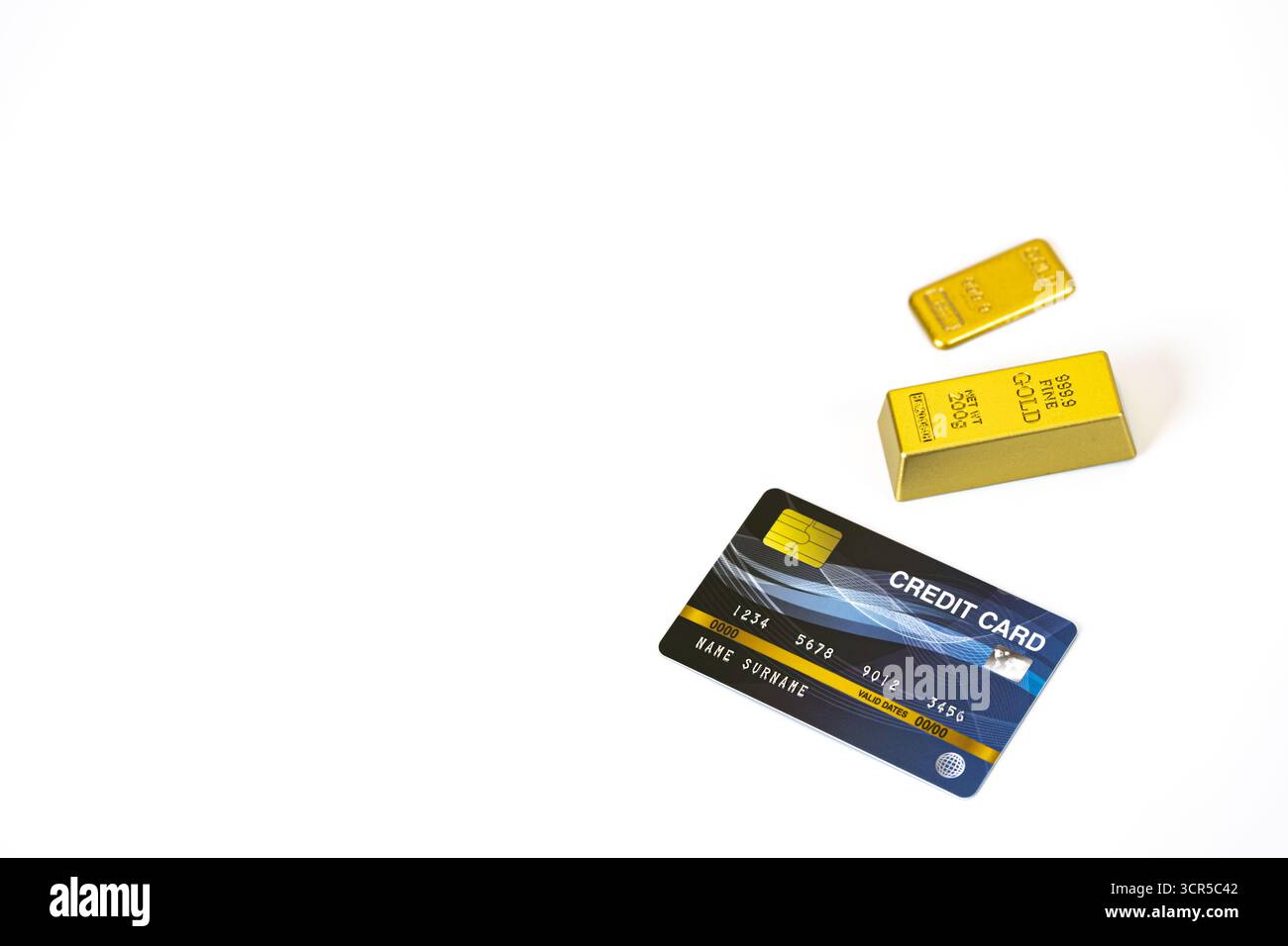 Eine Kreditkarte und Goldbarren auf weißem Hintergrund symbolisieren Wohlstand und finanzielle Sicherheit. Das Bild vermittelt ein Gefühl von Luxus und Wohlstand Stockfoto