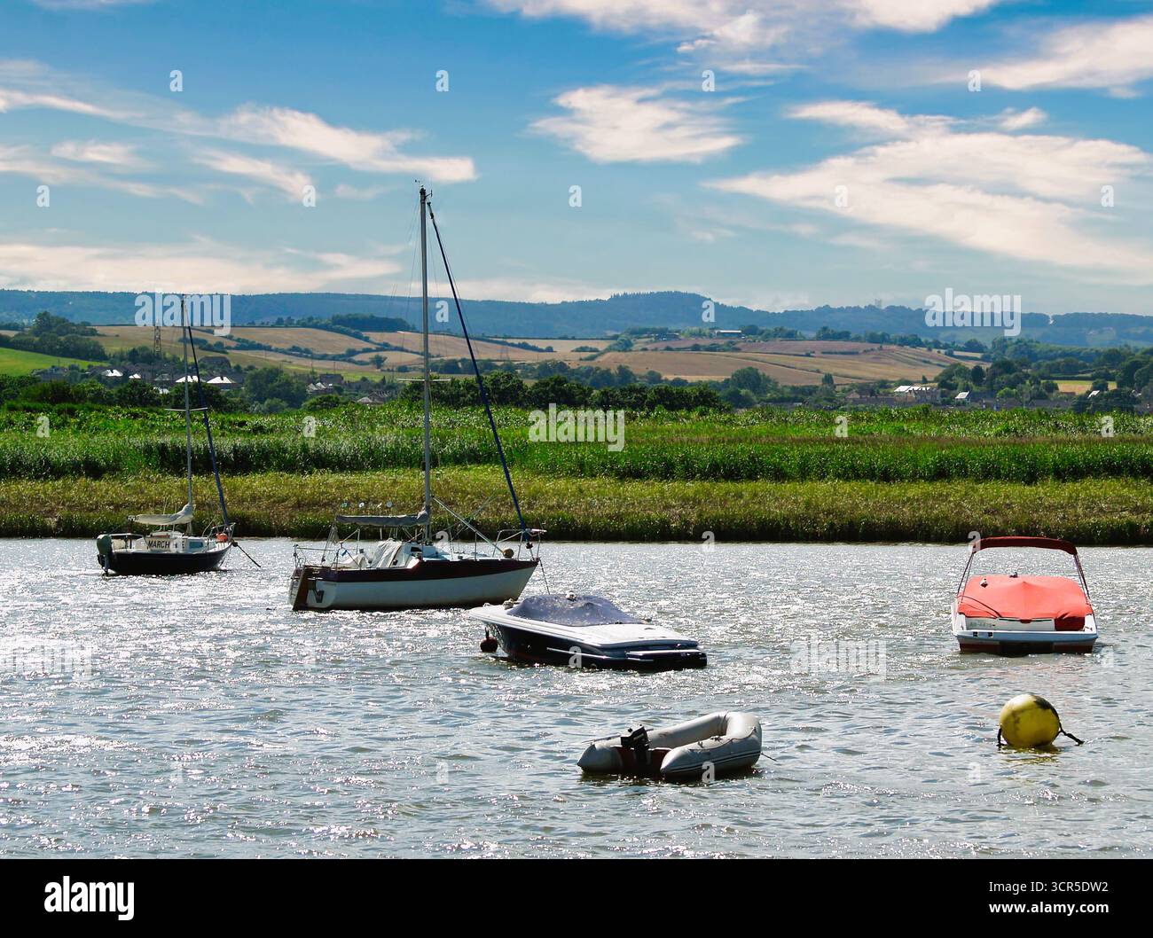 Vertäute Boote auf einem schimmernden Fluss exe in der Nähe von Exeter in Devon, Südwesten Englands. Stockfoto