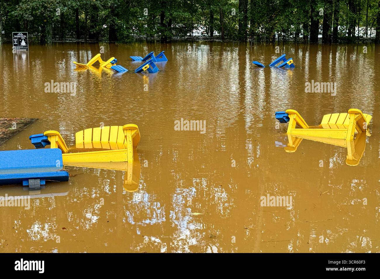Holzstühle sind teilweise in einem Erholungsgebiet von Hurrikan Helene Überschwemmungen getaucht. Stockfoto