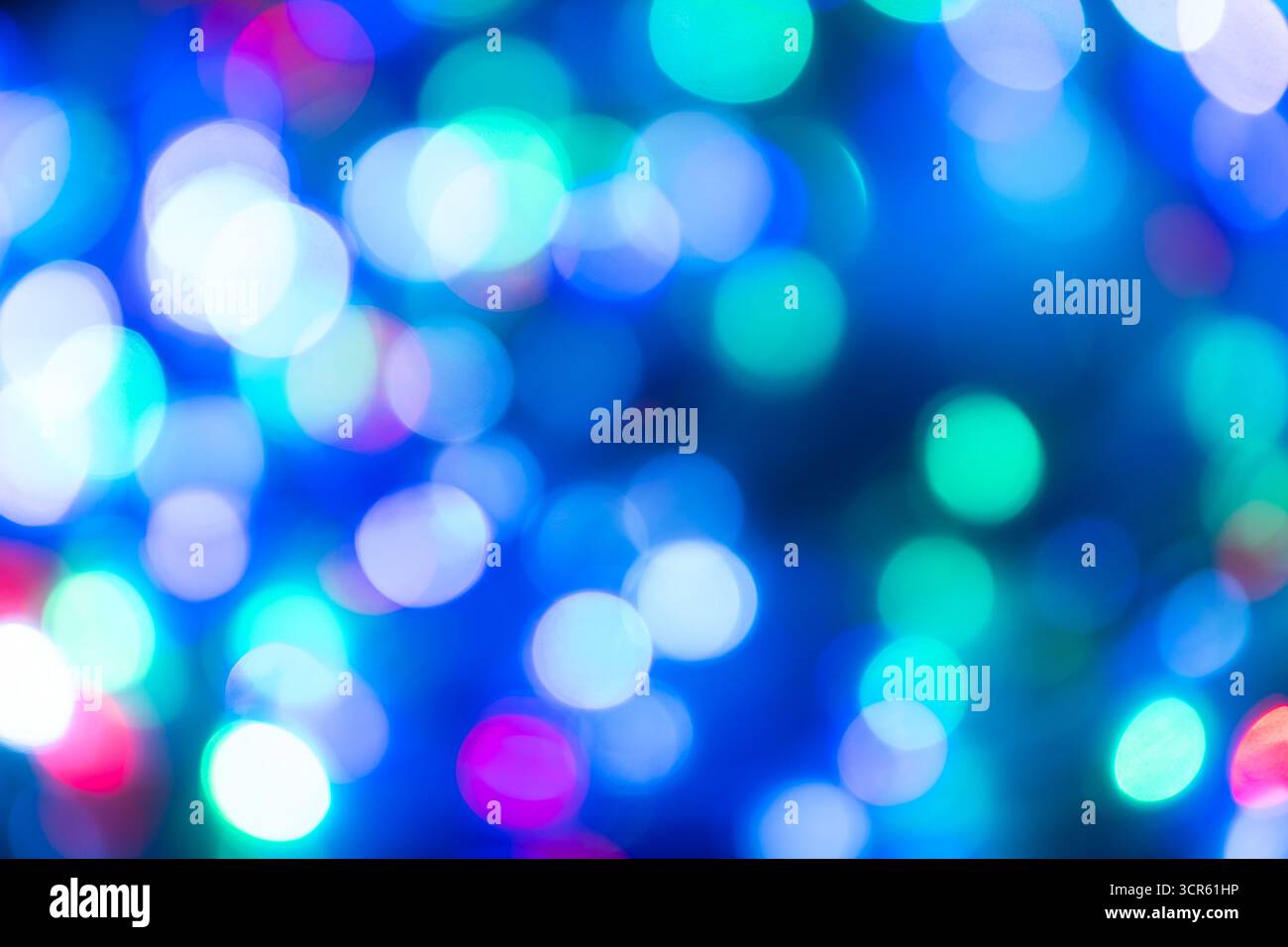 Abstrakter unscharfer Hintergrund mit leuchtenden blauen, grünen und lila Bokeh-Lichtern. Perfekt für festliche Designs, Weihnachtsmotive, Partyeinladungen, Stockfoto