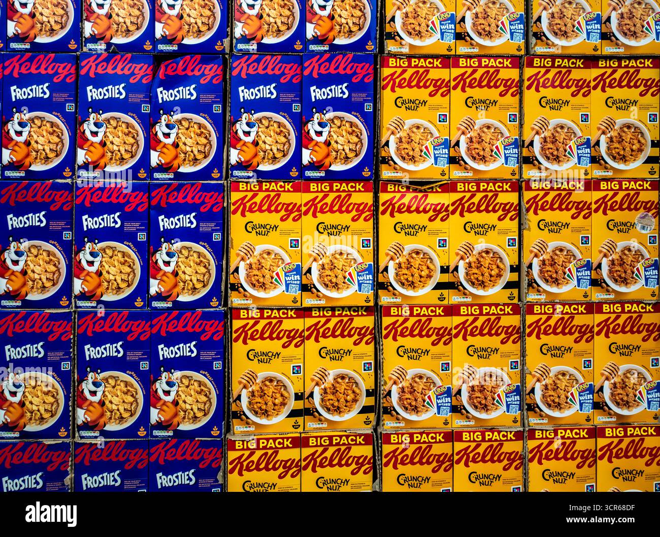 Kästen mit Kellogg’s Frosties und Crunchy Nut Frühstückszerealien, die in Supermarktregalen, Konsumgütern und Markenverpackungen im Einzelhandel gestapelt sind. Stockfoto