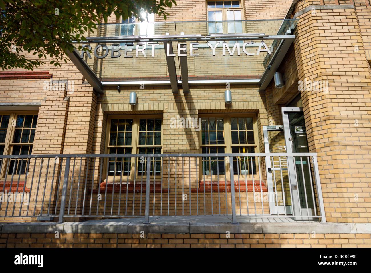 Vancouver, Kanada - 15. September 2025: Robert Lee YMCA-Gebäude mit gelber Ziegelfassade, Metallgeländern und Glasfenstern Stockfoto