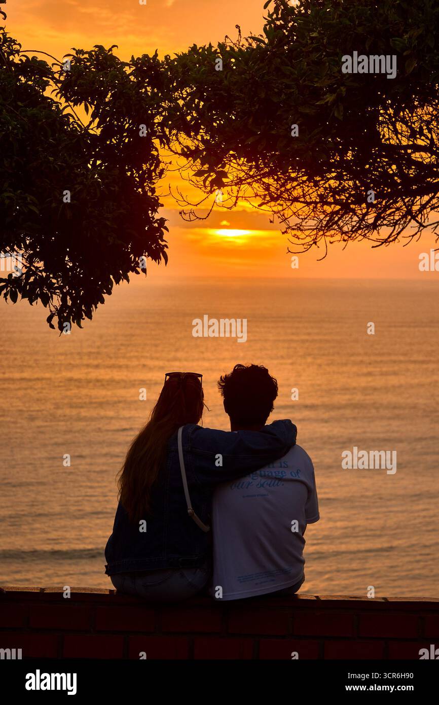 Goldene Momente am Meer während die Sonne unter dem Horizont über La Costa Verde untergeht, leuchtet die Liebe in Miraflores heller als je zuvor. Lima Peru. Stockfoto