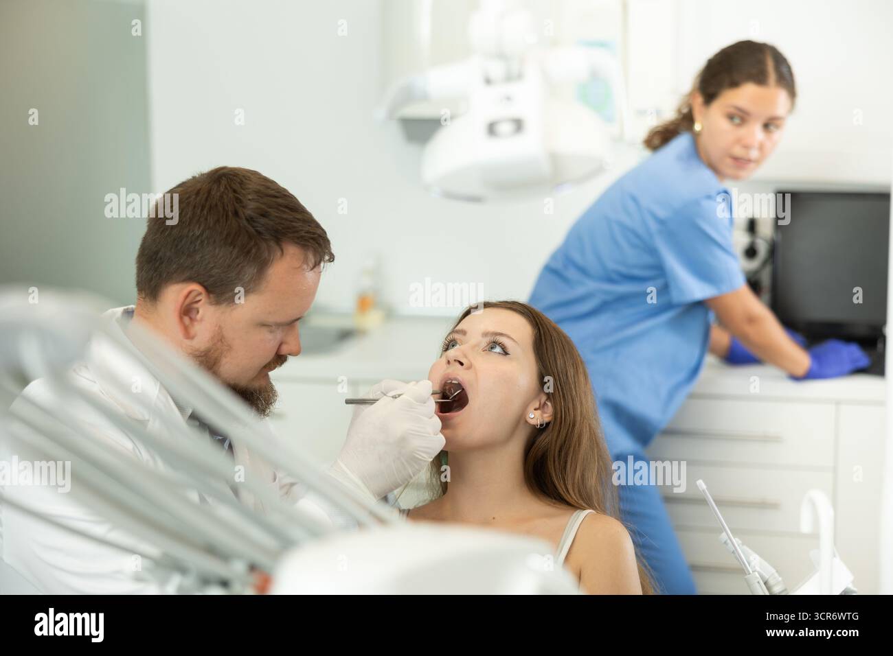 Frau, die ihre Zähne bei einem Zahnarzttermin überprüft Stockfoto