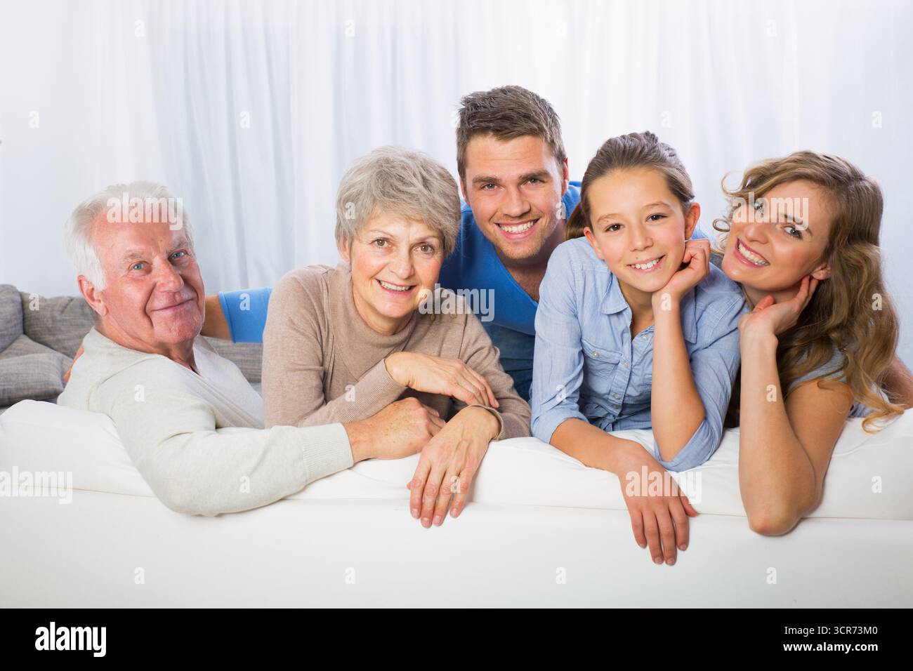 Familie mit Kind, Oma und Opa auf dem Sofa Stockfoto