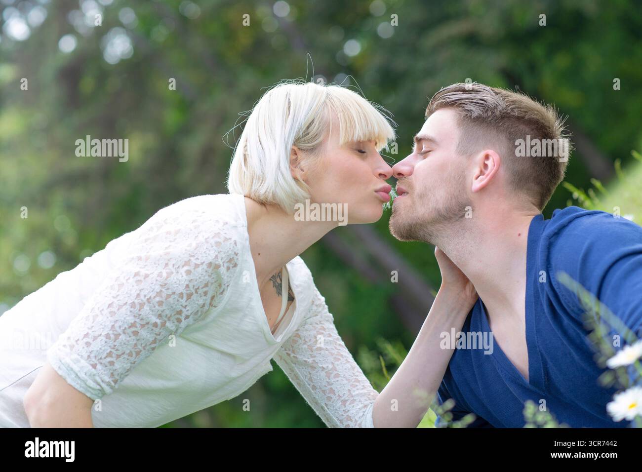 Ein verliebtes Paar steht auf einer Wiese und küsst Stockfoto