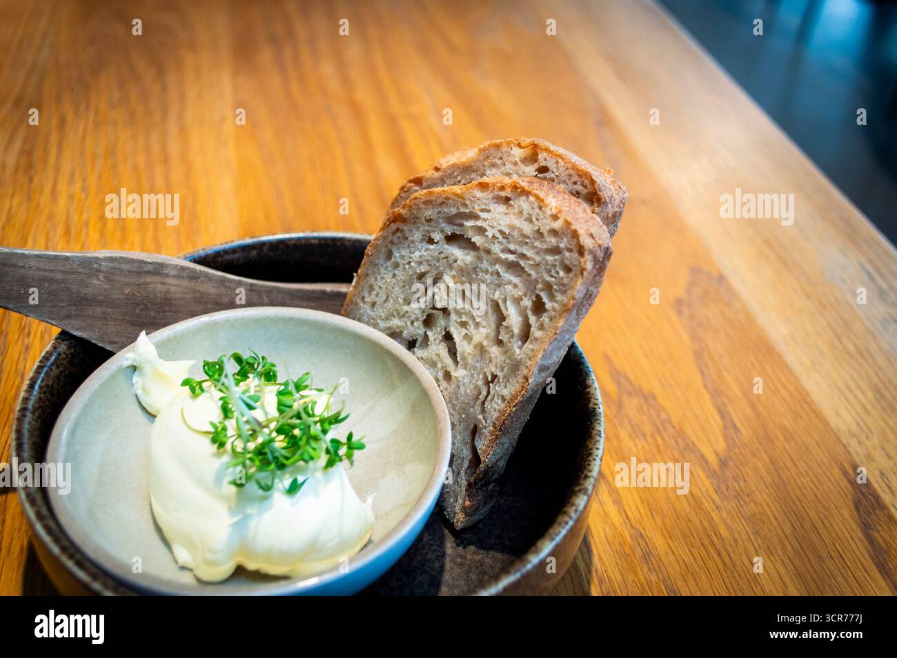 Zwei Scheiben Sauerteigbrot mit Butter an einem Esstisch in einem lokalen Restaurant in Norwegen Stockfoto