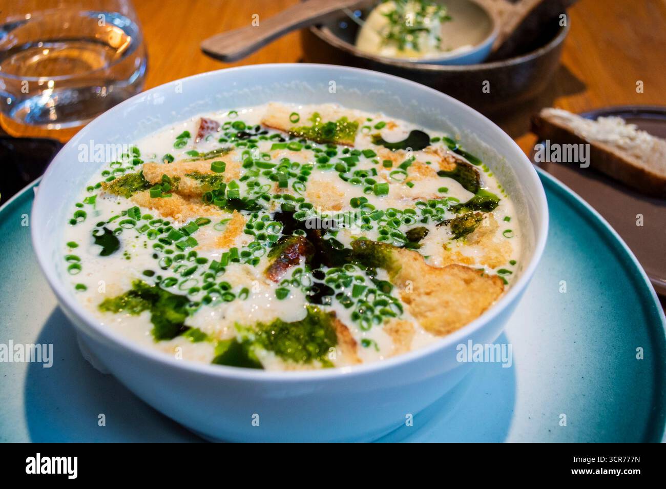 Blick von oben auf traditionelle norwegische Fischsuppe, cremige Brühe serviert in einer weißen Schüssel mit Fischfilet, Brot und frischen Zwiebeln von einem Einheimischen aus Norwegen Stockfoto