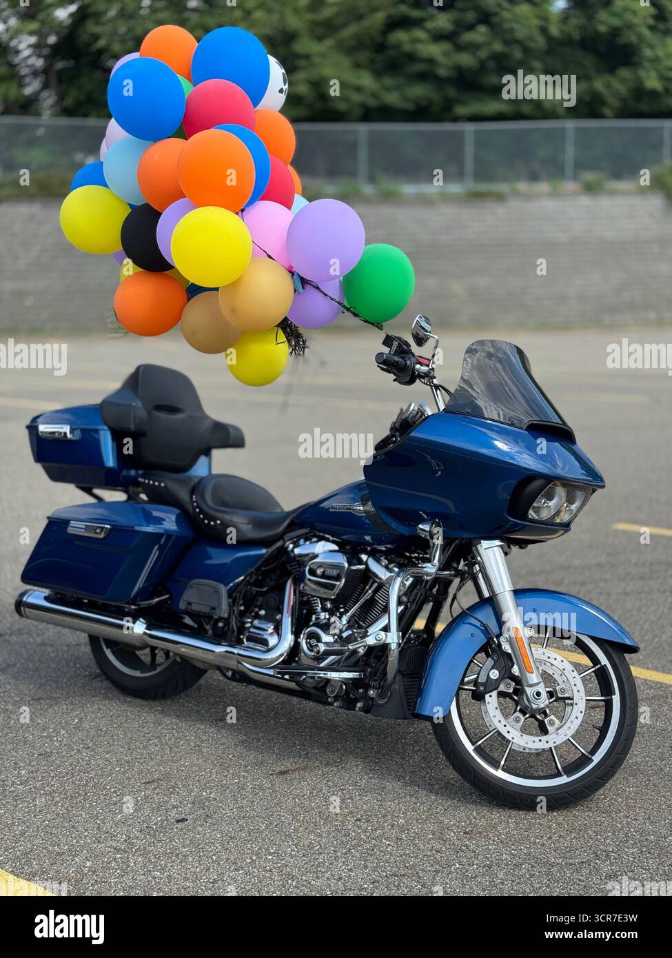 Geparktes blaues Tourenmotorrad mit bunten Ballons am Lenker Stockfoto