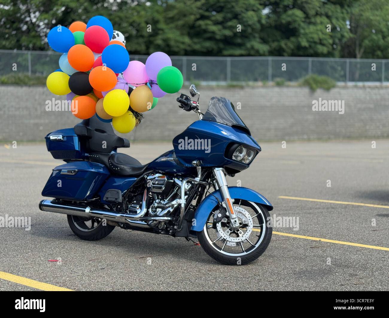 Geparktes blaues Tourenmotorrad mit bunten Ballons am Lenker Stockfoto