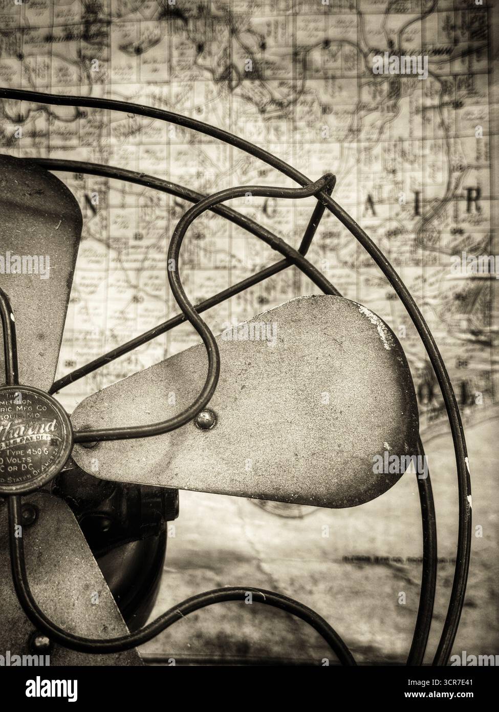 Antiker Metallfächer mit alter Karte im Hintergrund jn Sepia Ton - Smartphone-aufgenommenes Stockfoto