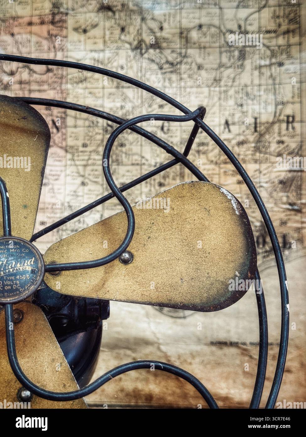 Antiker Metallventilator mit alter Karte im Hintergrund - Smartphone-aufgenommenes Stockfoto