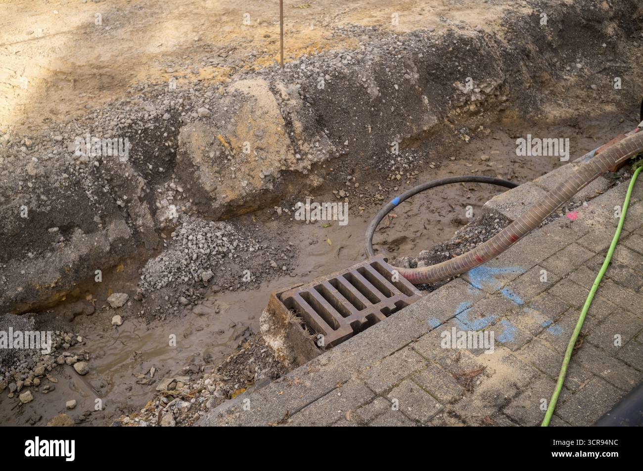 Borken, NRW, Deutschland, Grabenaushub mit Erde, Schlamm, Kies, einem Sturmabfluss und Rohren während der Bauarbeiten Stockfoto