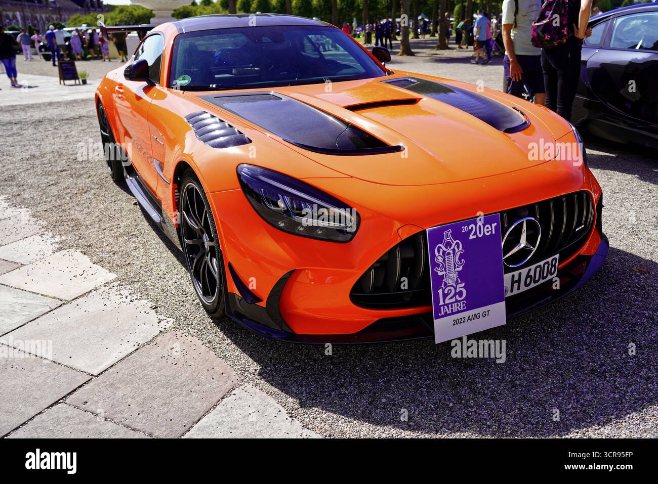 Oldtimer Classic, Gala International Concours d'Elegance Schwetzingen 2025, Deutschland, Europa, ein orangener Sportwagen mit einer Gedenktafel zur Feier eines 125. An Stockfoto