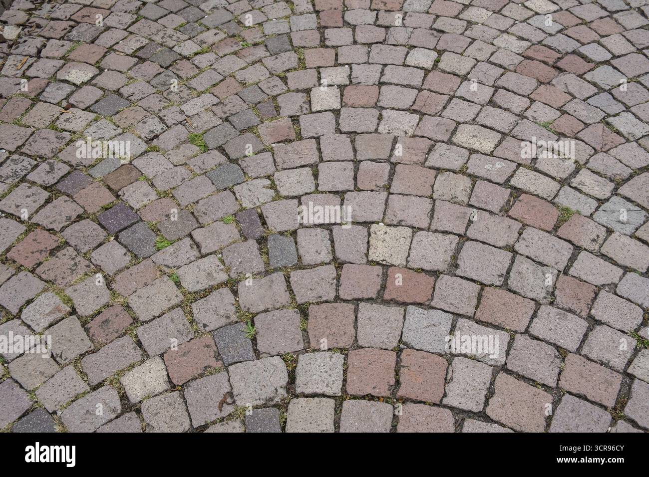 Bodenbelag aus Pflastersteinen mit Bogenmuster in Grau- und Röttönen, Hintergrund, Textur, Deutschland Stockfoto