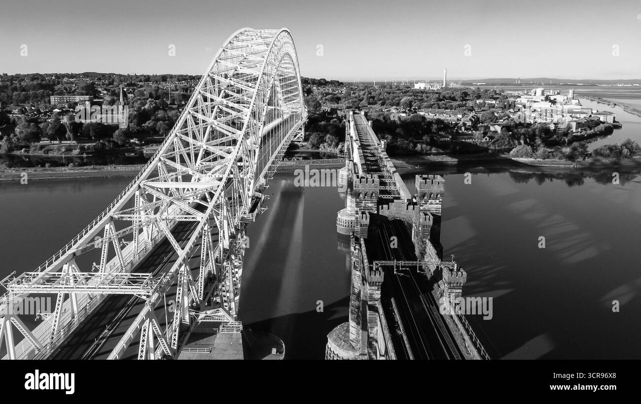 Schwarzweißblick aus der Luft auf die Silver Jubilee Bridge und das Eisenbahnviadukt über den Fluss Mersey Stockfoto