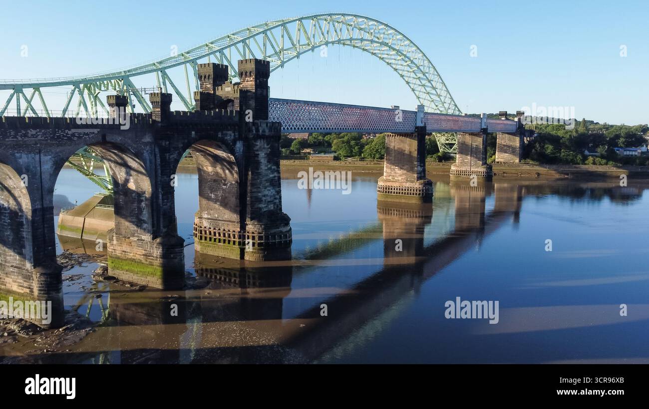 Aus der Vogelperspektive auf die Silver Jubilee Bridge und das Eisenbahnviadukt über den Fluss Mersey bei Widnes Stockfoto