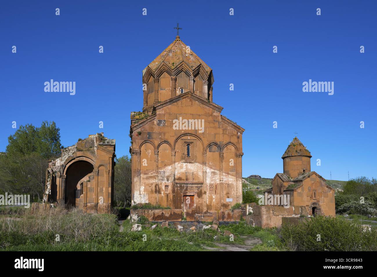 Historische Backsteinkirche unter klarem Himmel, umgeben von Vegetation, Kreuzkuppelkirche, Marmashen Kloster, Marmashen Vank, Provinz Shirak, Armenien Stockfoto