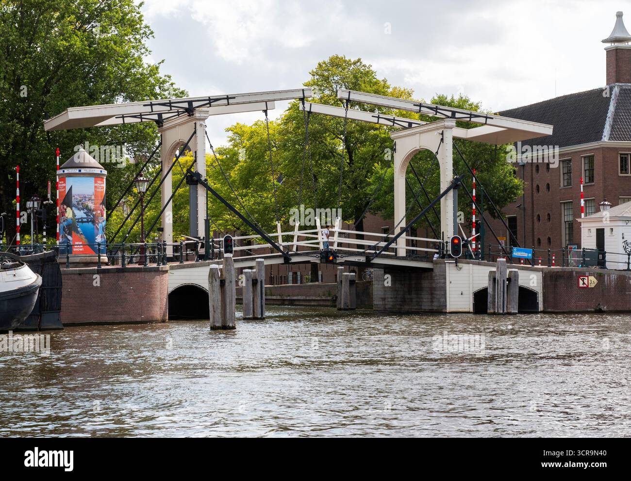 Amsterdam, Niederlande - 5. August 2025: Eine Zugbrücke in Amsterdam steht offen, sodass Boote vorbeifahren können. Stockfoto