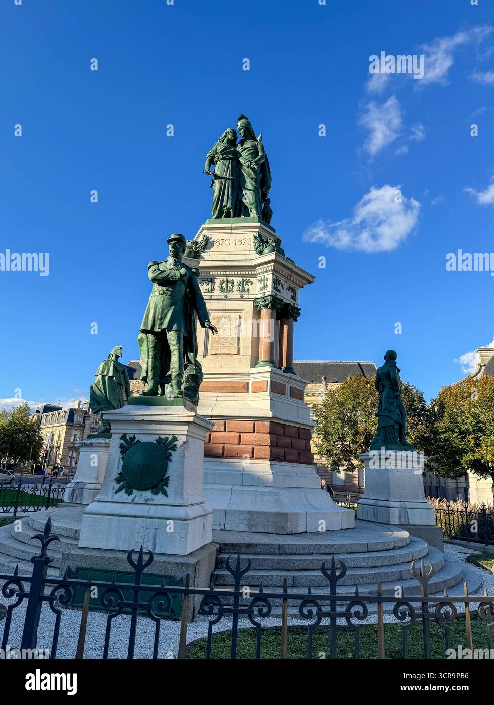 Blick auf das Monument des Trois Belages und das Monument lecourbe im Stadtzentrum von Belfort, mit Bronzestatuen vor der historischen französischen Architektur - Smartphone-aufgenommenes Stockfoto