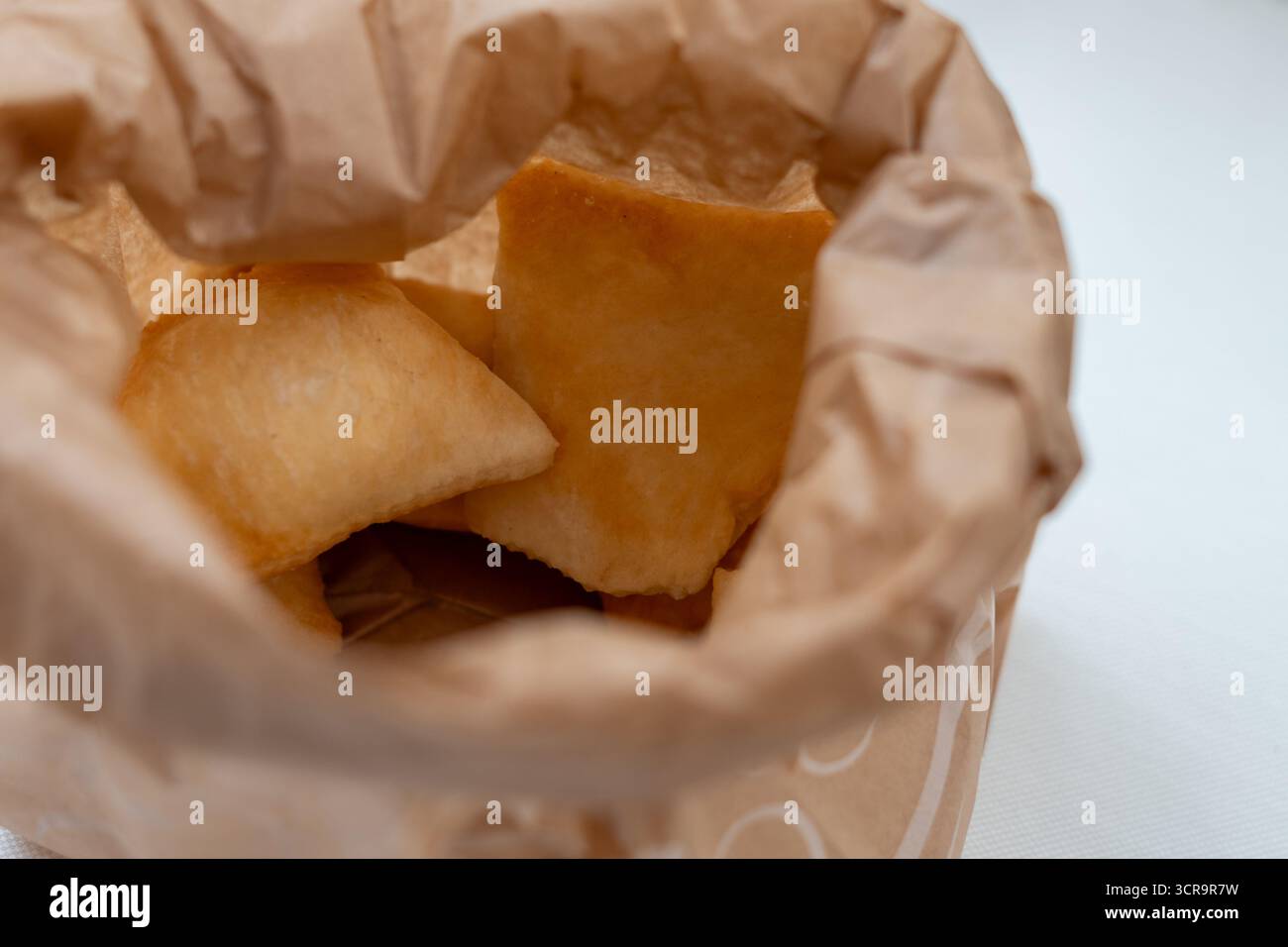 Warme, einladende Lichter strömen in einen privaten Veranstaltungsort, in dem die Gäste einen wunderschönen Mittagstisch genießen können Stockfoto