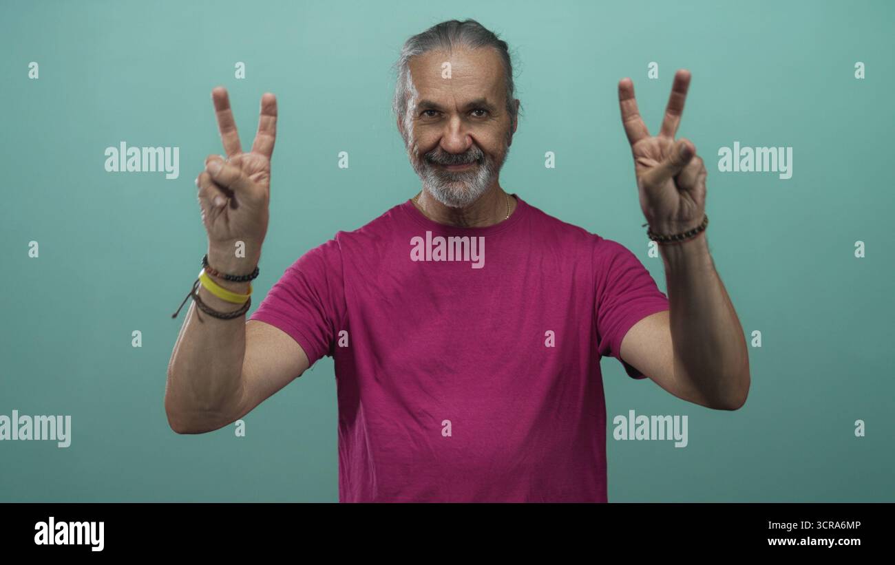 Heiliger Mann mittleren Alters mit langen Haaren, der mit beiden Händen Luftzitierungen in einem blaugrünen Studio zeigt; verspielte Skepsis. Stockfoto