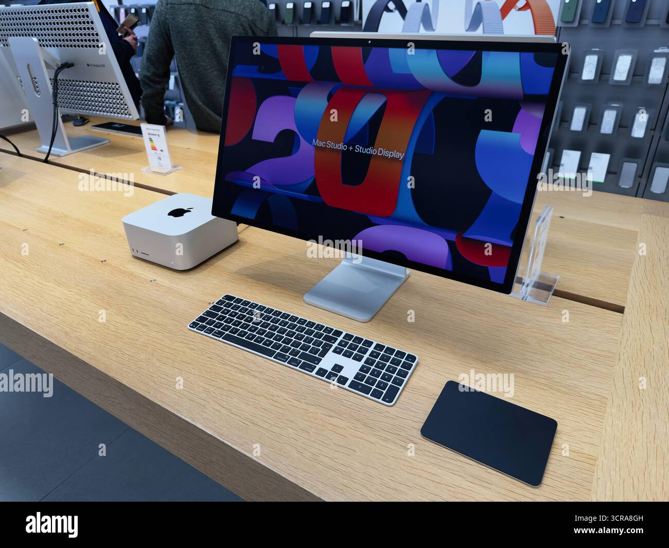 Manchester, Großbritannien - 29. September 2025: Moderner Apple Mac Studio Computer auf einem Holztisch mit großem Monitor und Tastatur in einem Ausstellungsraum. Stockfoto