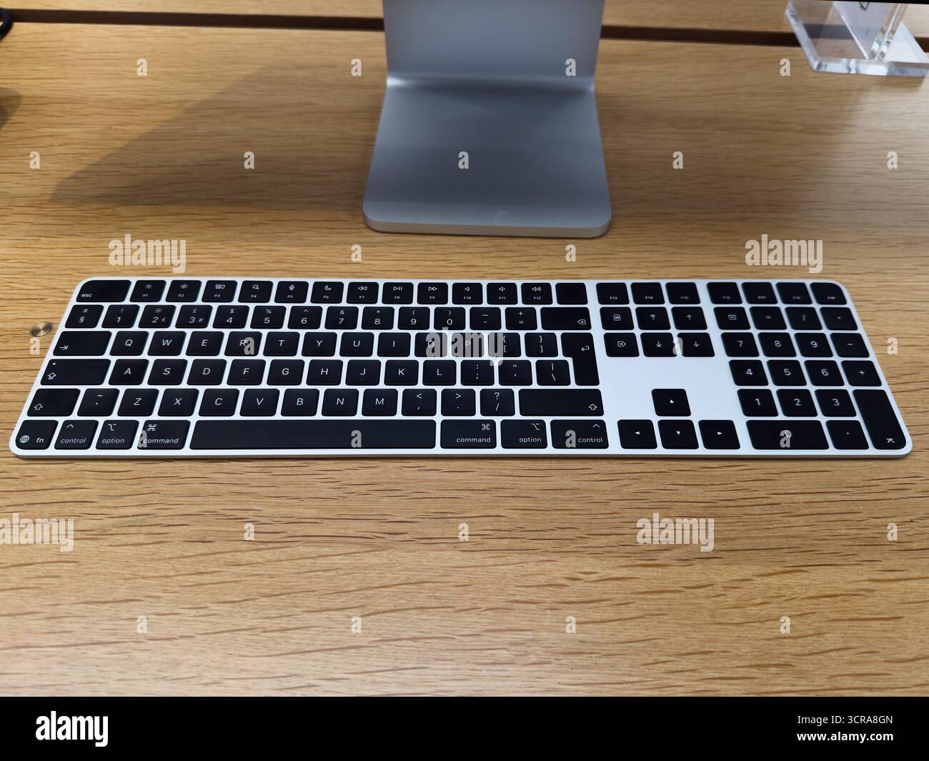 Manchester, Großbritannien – 29. September 2025: Die schlanke Apple Magic Tastatur auf einem Schreibtisch aus warmem Holz sorgt für einen sauberen, produktiven Arbeitsplatz. Stockfoto