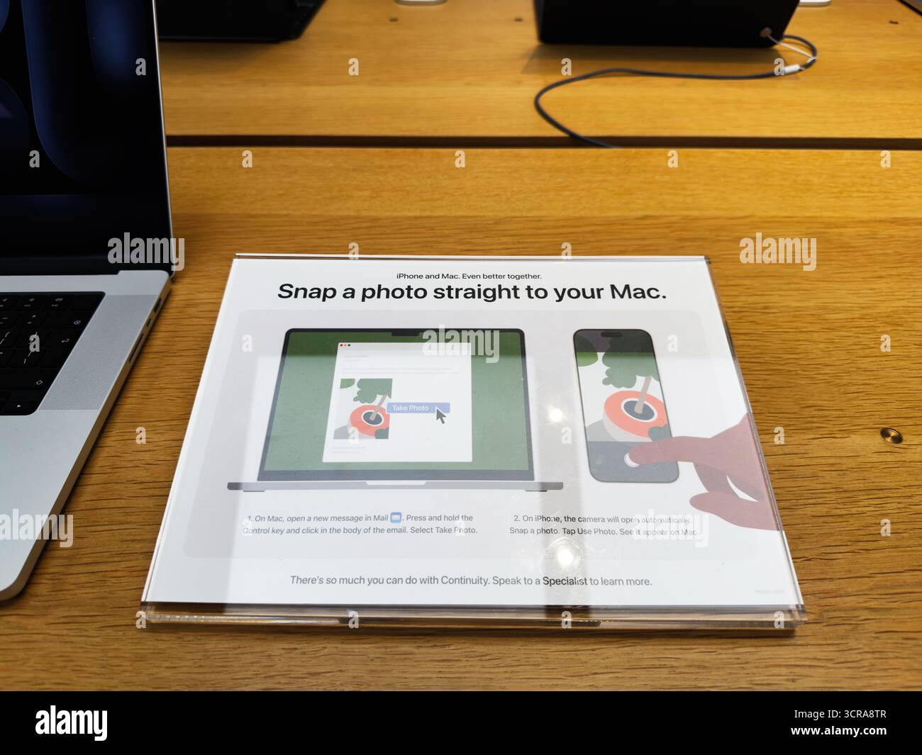 Manchester, Großbritannien – 29. September 2025: Ein Vorführschild auf einem Holzschreibtisch zeigt, wie man ein Foto direkt auf einem Mac aufnimmt. Saubere, moderne Technikszene für E Stockfoto