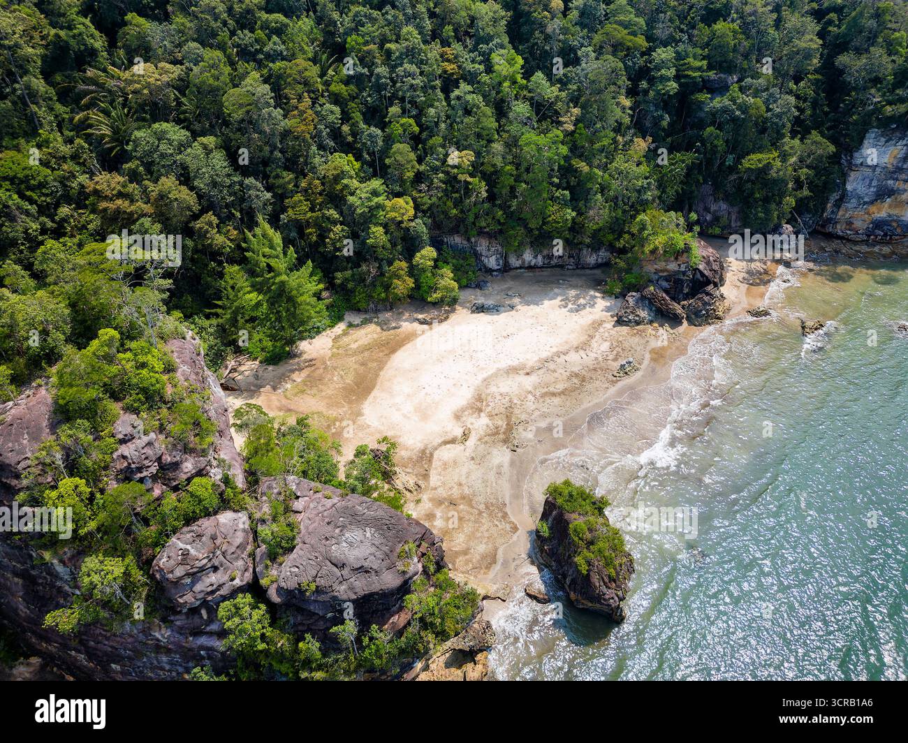 Drohnenblick auf abgelegenen Sandstrand und tropischen Regenwald in Borneo. Stockfoto
