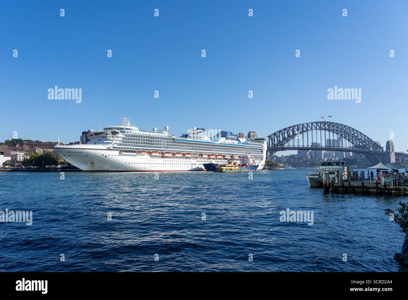 Ein Karneval Adventure Kreuzfahrtschiff mit Sydney Harbour Bridge im Hintergrund. Sydney, NSW, Australien. Stockfoto