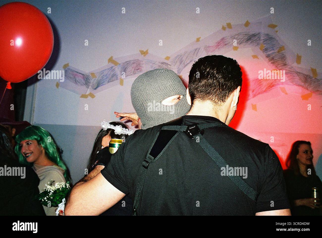 35mm Farbfilmfoto einer Studentenkostümparty an einer Universität in Belgrad. Blitzlicht, chaotisch, unterhaltsam, raue Energie – analoge Nightlife-Momentaufnahme. Stockfoto