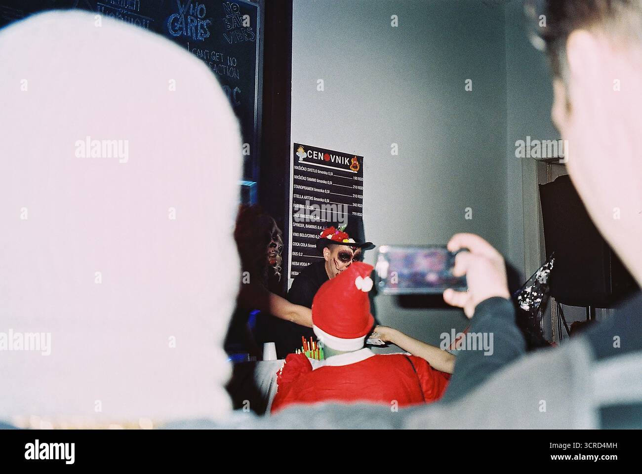 35mm Farbfilmfoto einer Studentenkostümparty an einer Universität in Belgrad. Blitzlicht, chaotisch, unterhaltsam, raue Energie – analoge Nightlife-Momentaufnahme. Stockfoto