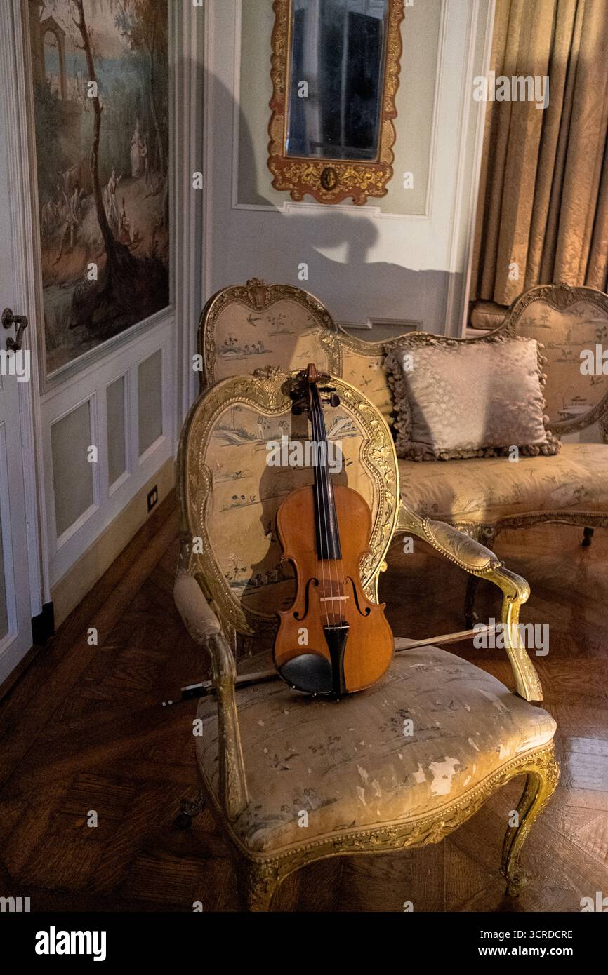 Geige und Bogen auf einem schicken Stuhl in einem Studentenzimmer im Rosen House in Caramoor in Katonah, New York. Stockfoto