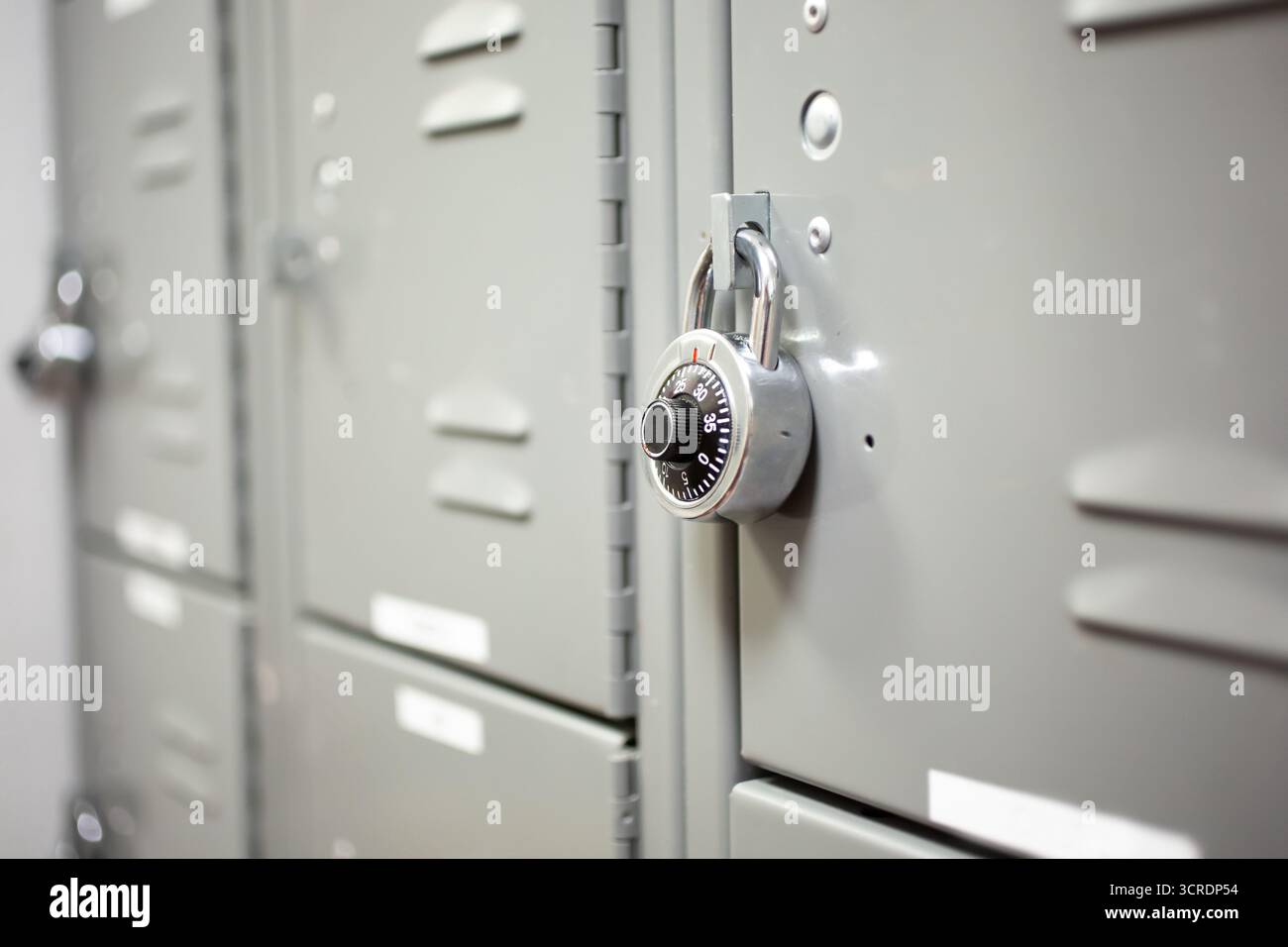 Blick auf eine Reihe von Schließfächern mit kombiniertem Vorhängeschloss mit Wählknopf. Stockfoto