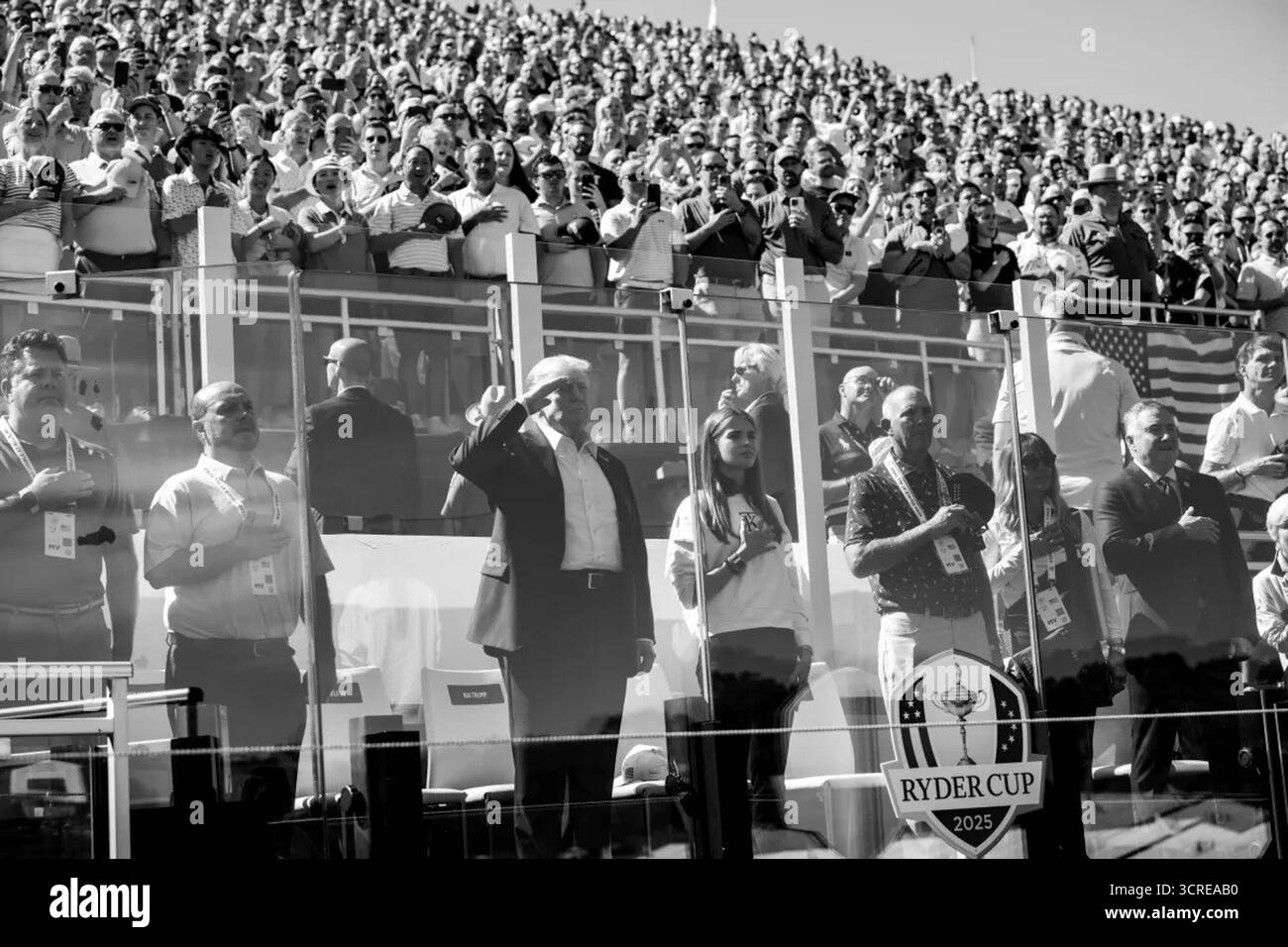 Präsident Donald J. Trump grüßt während der Nationalhymne am Eröffnungstag des Ryder Cup 2025 auf dem Bethpage Black Golf Course in Farmingdale, New York, zusammen mit seiner Enkelin Kai Madison Trump. September 2025. Bild mit freundlicher Genehmigung des Weißen Hauses. Stockfoto