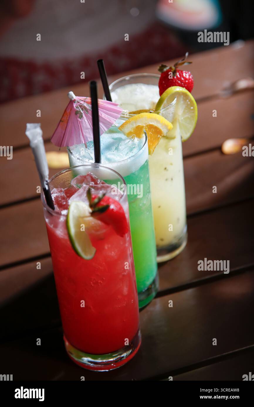 Blick auf eine Reihe farbenfroher Cocktails auf einem Restauranttisch. Stockfoto