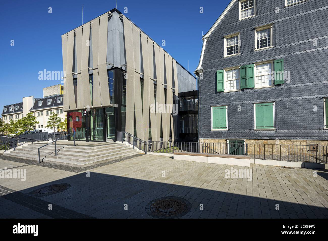 Moderne Glasfassade neben einem alten Haus mit bunten Fensterläden, starkem Licht- und Schattenspiel, Museum für frühe Industrialisierung in der Wuppertaler Bar Stockfoto