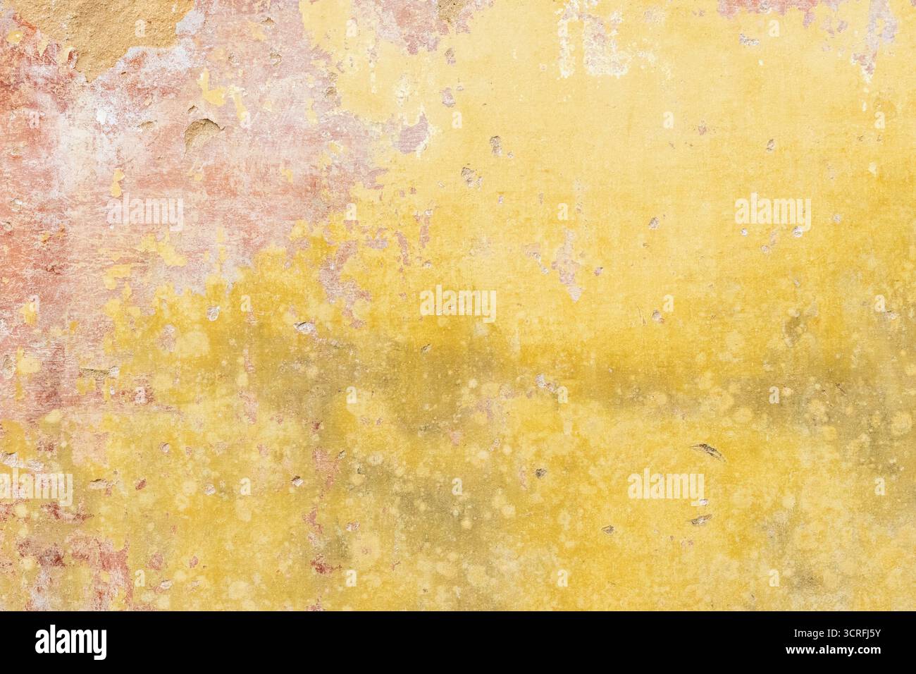 Nahaufnahme einer verwitterten gelben Wand mit abblätternder Farbe und strukturierter Oberfläche, die einen Vintage- oder Antikeffekt erzeugt Stockfoto