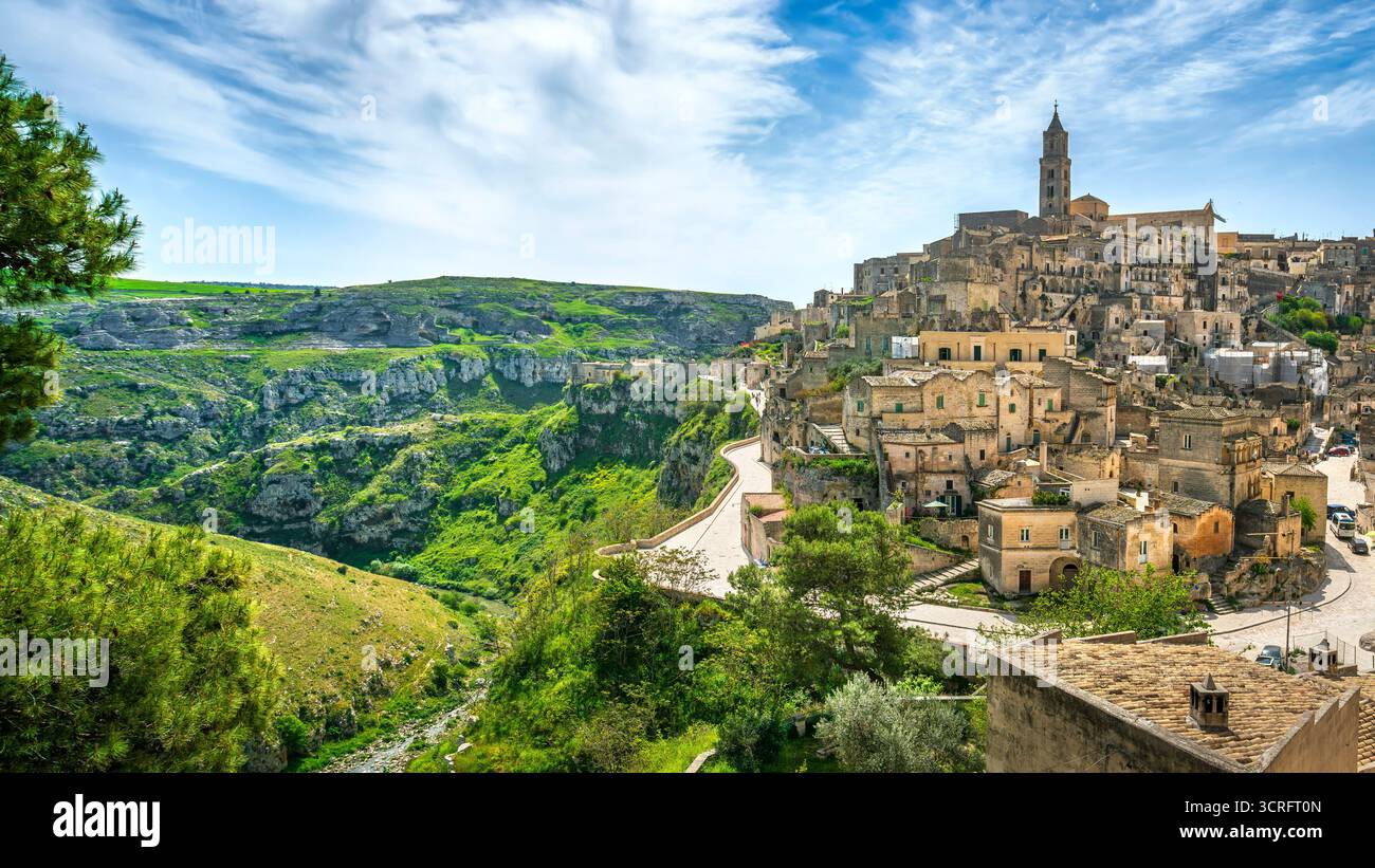Panoramablick auf das historische Sassi di Matera, die alten Höhlenhäuser aus Kalkstein mit dem Kirchturm der Kathedrale. Gravina Canyon in Basilicata, Italien Stockfoto