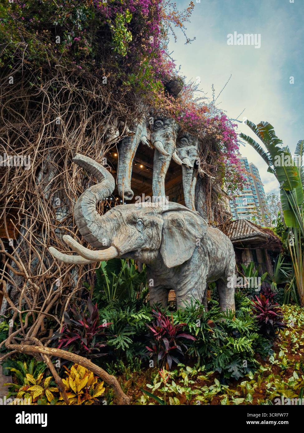 Eine prächtige Statue mit drei Elefanten steht vor einem großen Gebäude Stockfoto