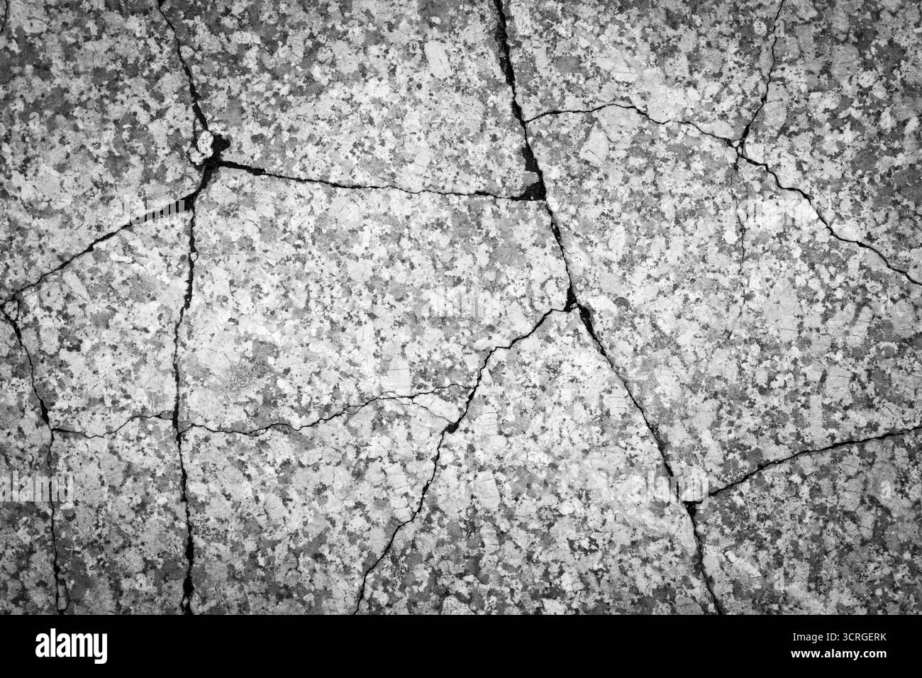 Rissige Betonwandoberfläche in Schwarz-weiß, beschädigter Strukturhintergrund Stockfoto